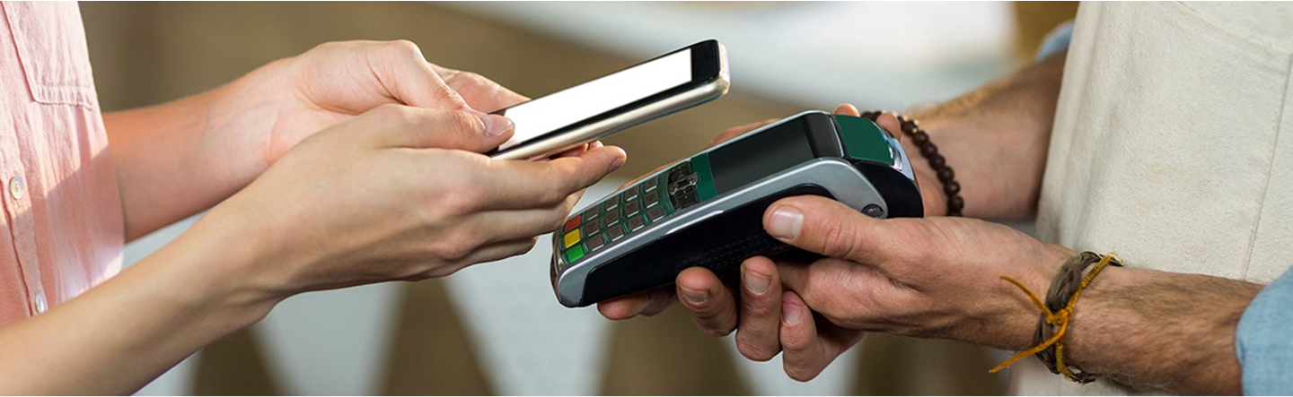 Customer making a contactless payment using a mobile phone and PDQ card reader