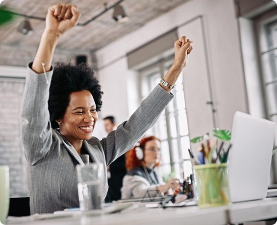 Excited businesswoman celebrating funding success at her desk after merchant cash advance approval